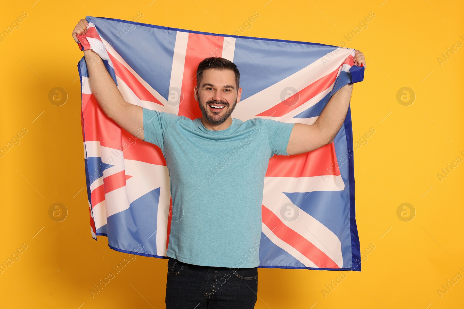 Photo of Man with flag of United Kingdom on yellow background