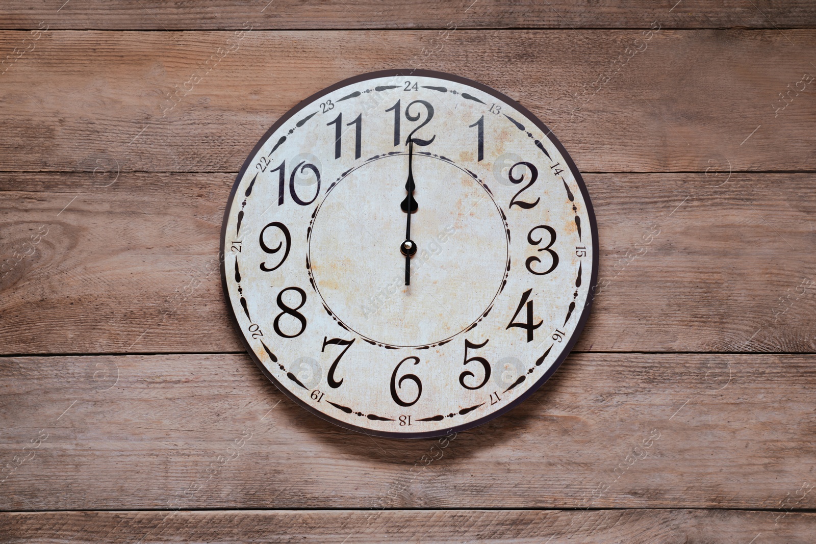 Photo of Stylish round clock on wooden table, top view. Interior element