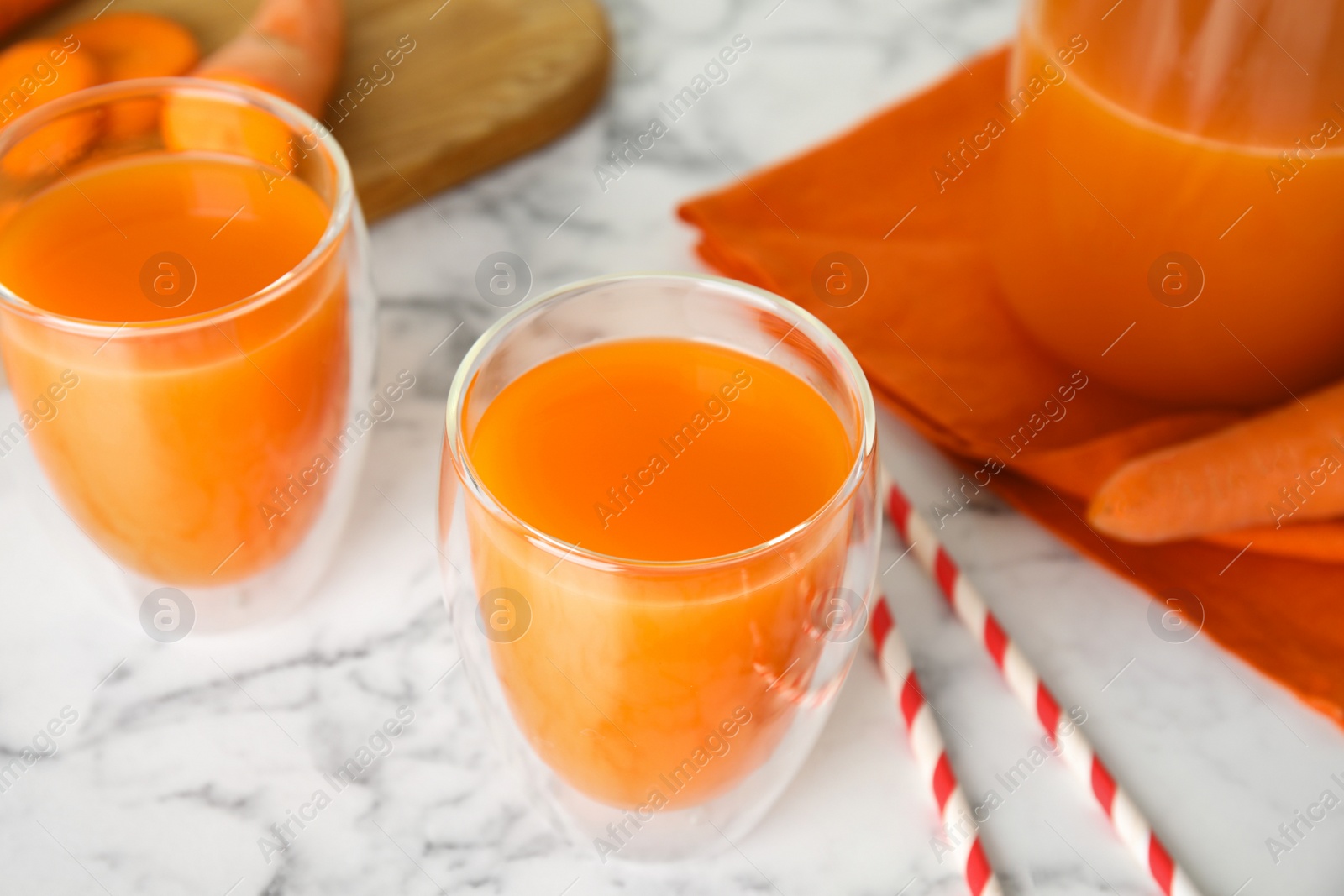 Photo of Freshly made carrot juice on white marble table