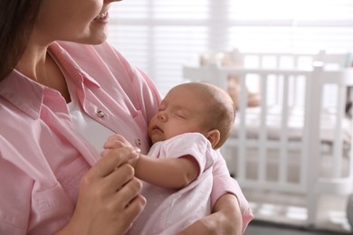 Young woman with her little baby at home, closeup. Space for text