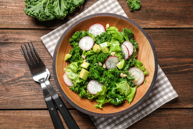 Photo of Delicious kale salad on wooden table, flat lay