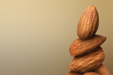 Almond nuts on light brown gradient background, space for text