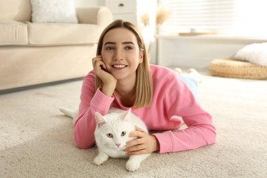 Photo of Young woman with her beautiful white cat at home. Fluffy pet