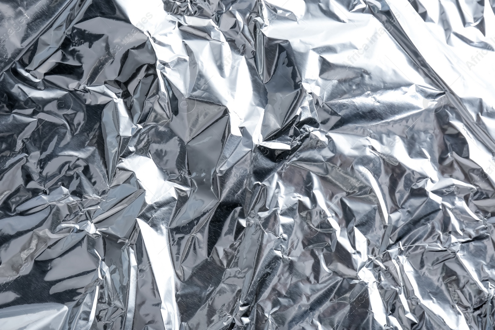 Photo of Crumpled silver foil as background, closeup view