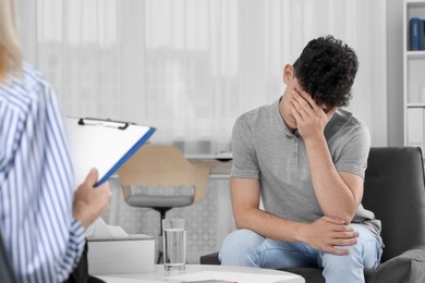 Photo of Psychologist working with teenage boy in office. Teenager problems