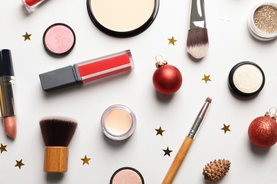 Photo of Flat lay composition with makeup products and Christmas decor on white background
