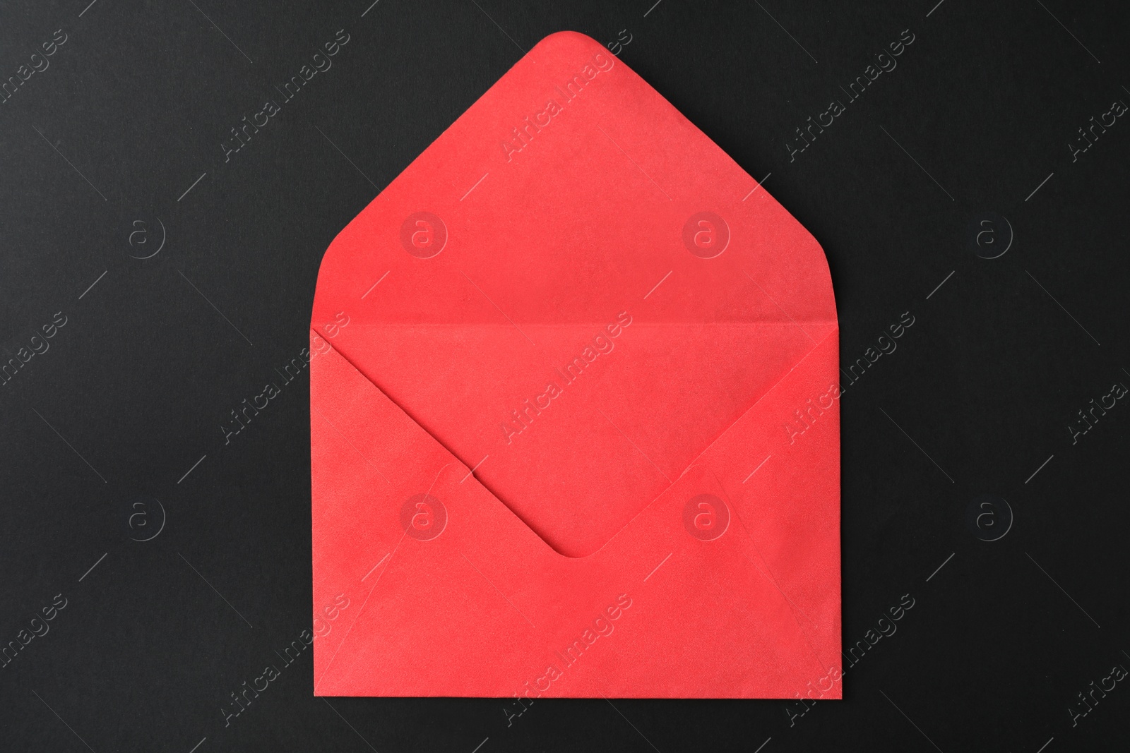 Photo of Red paper envelope on black background, top view