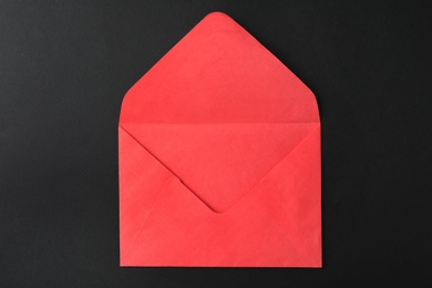 Red paper envelope on black background, top view