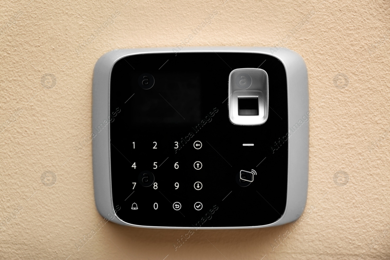 Photo of Modern alarm system with fingerprint scanner on color wall
