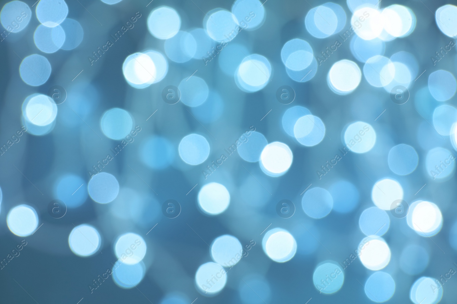 Photo of Blurred view of Christmas lights on color background