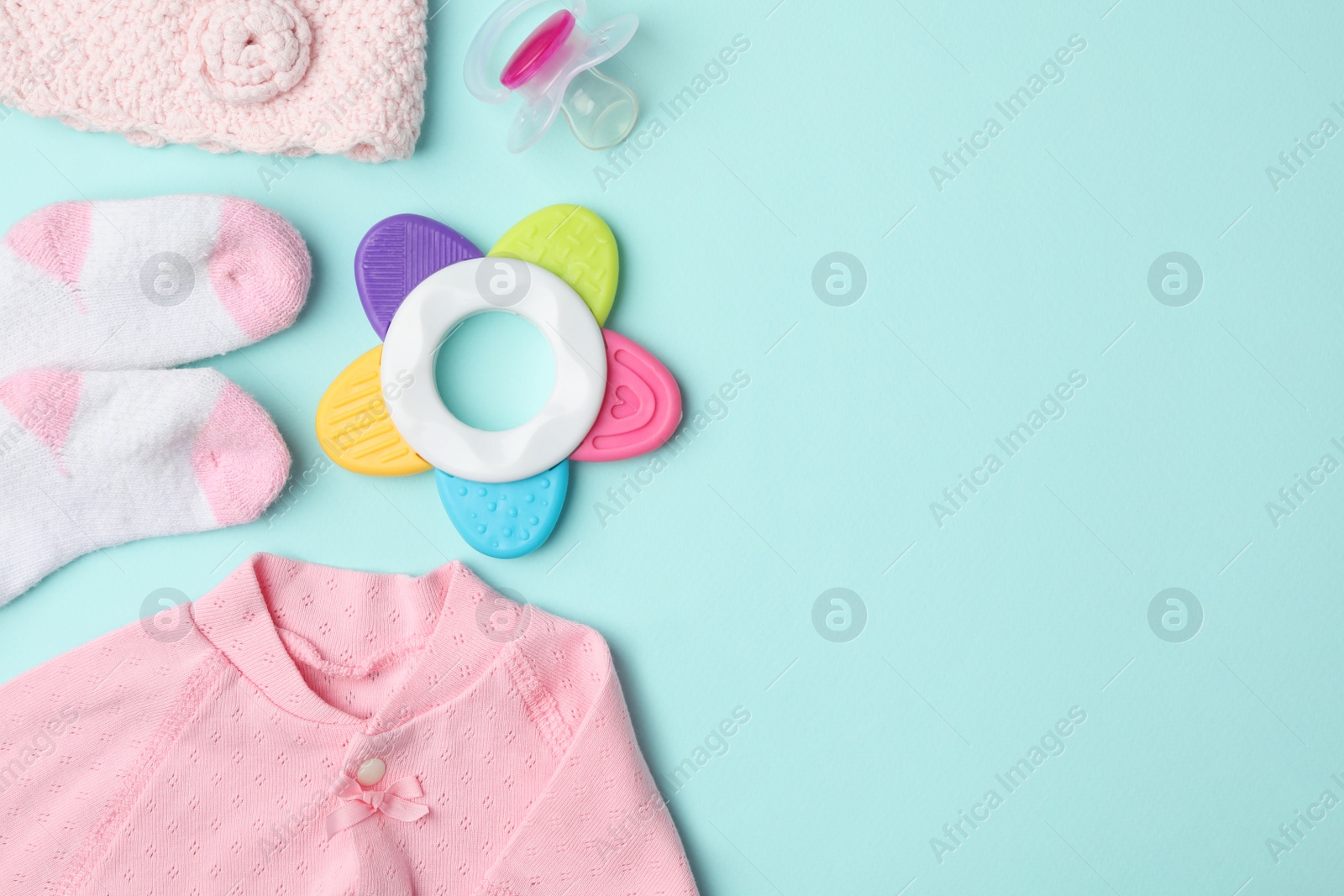 Photo of Flat lay composition with child's clothes and accessories on light blue background, space for text