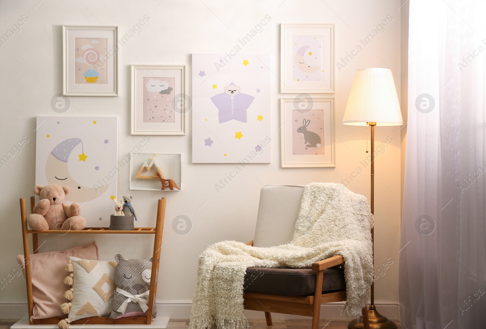 Photo of Stylish child's room interior with comfortable armchair and beautiful pictures