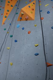 Photo of Climbing wall with holds in gym. Extreme sport