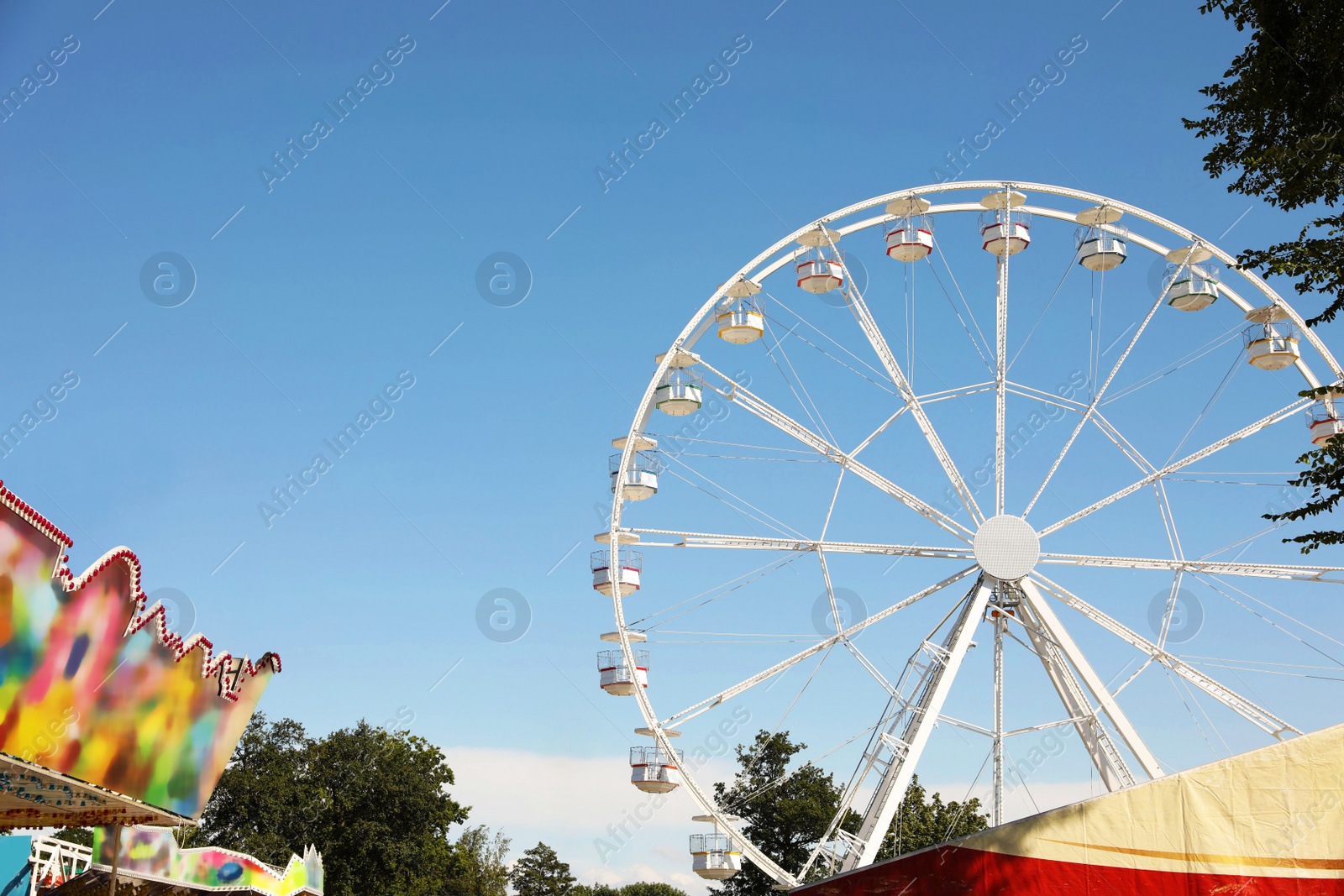 Photo of Beautiful white ferris wheel against blue sky