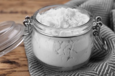 Photo of Glass jar of natural starch on wooden table, closeup