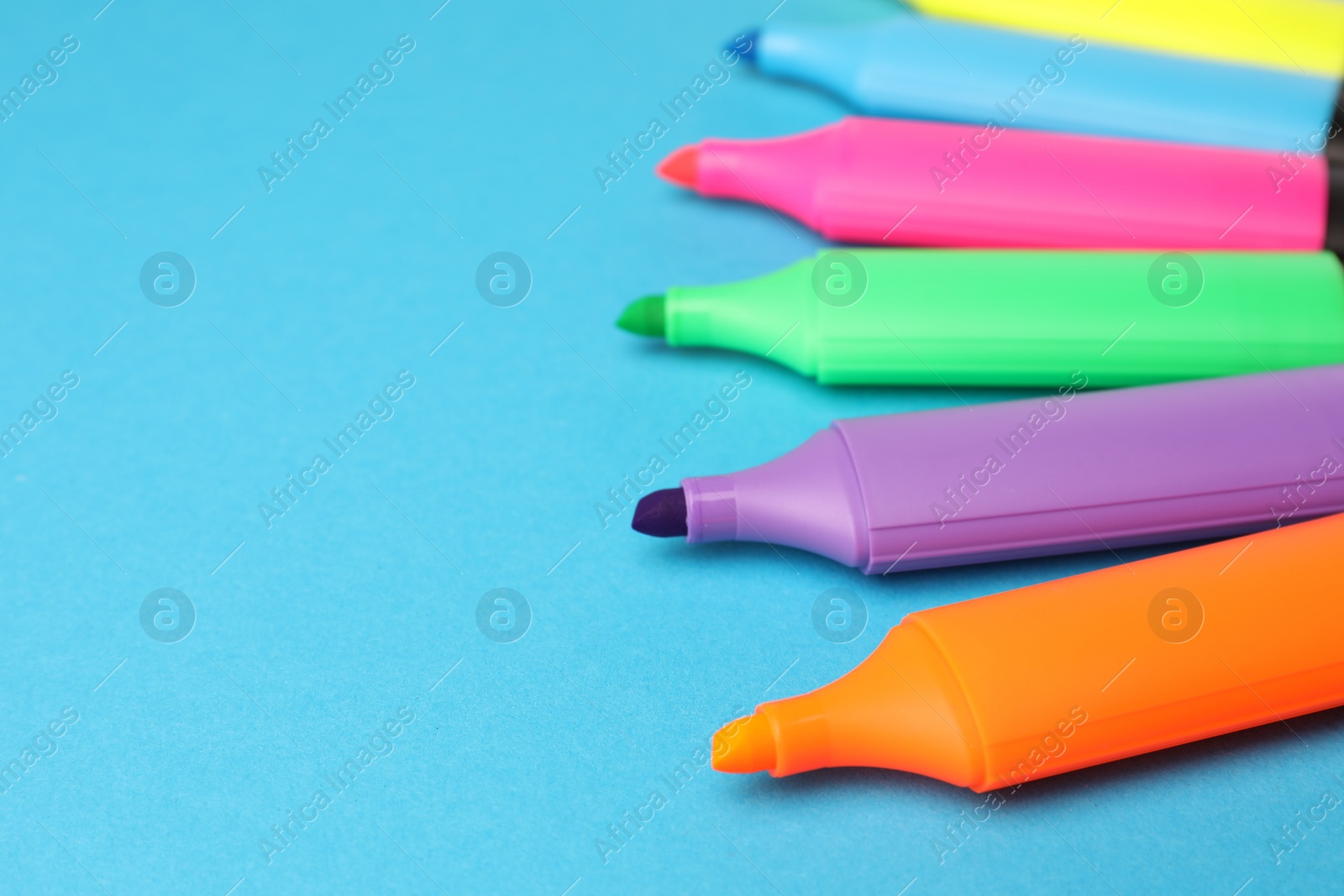 Photo of Bright markers on light blue background, space for text