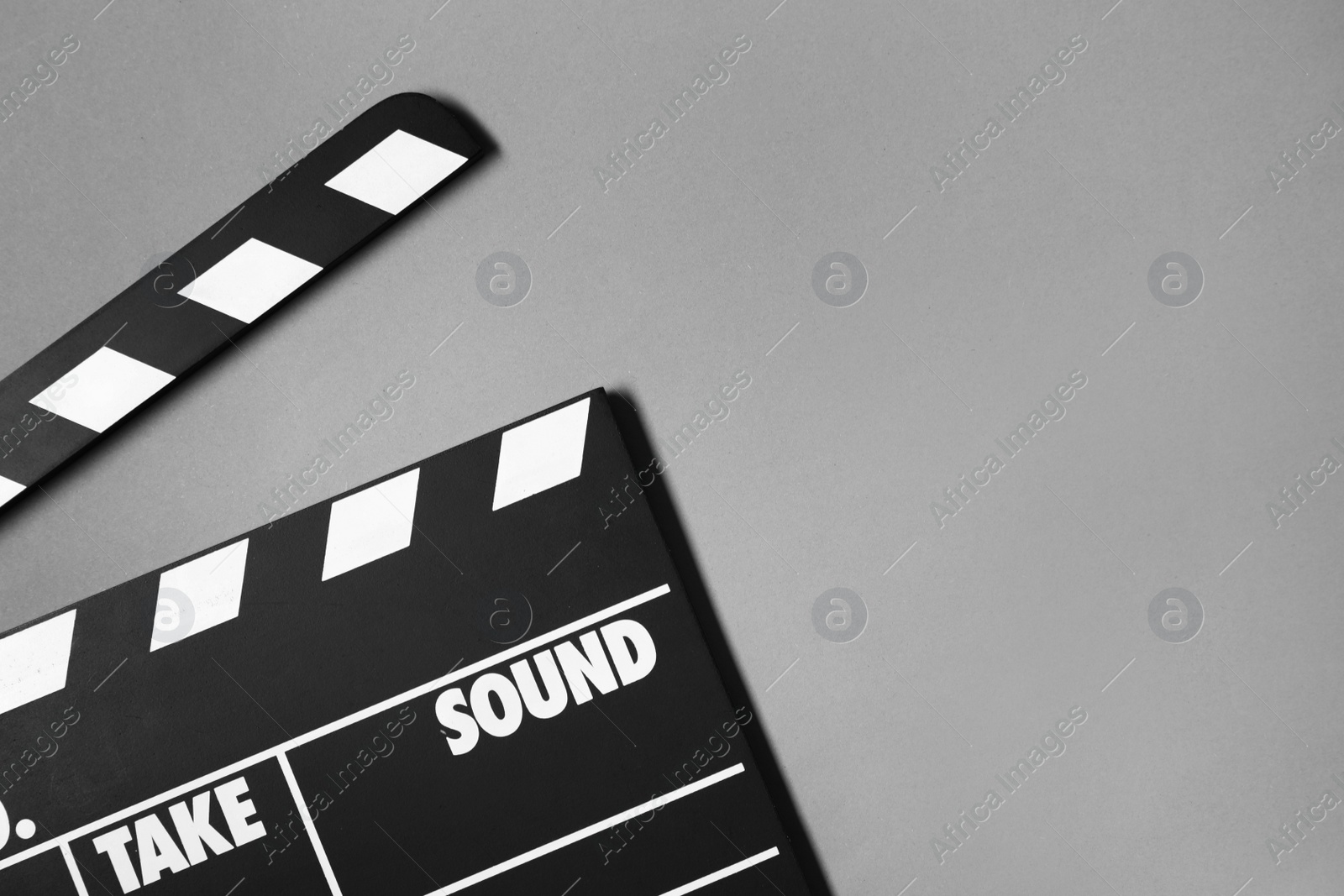 Photo of Clapperboard on grey background, top view with space for text. Cinema production