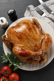 Photo of Tasty roasted chicken served on grey textured table, flat lay