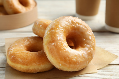 Photo of Delicious donuts on white wooden table, closeup