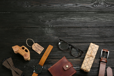 Photo of Flat lay composition with male accessories on black wooden background, space for text. Father's Day