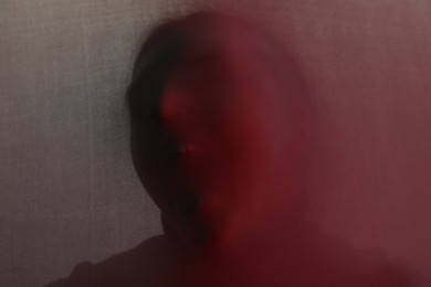 Silhouette of creepy ghost behind cloth, color toned