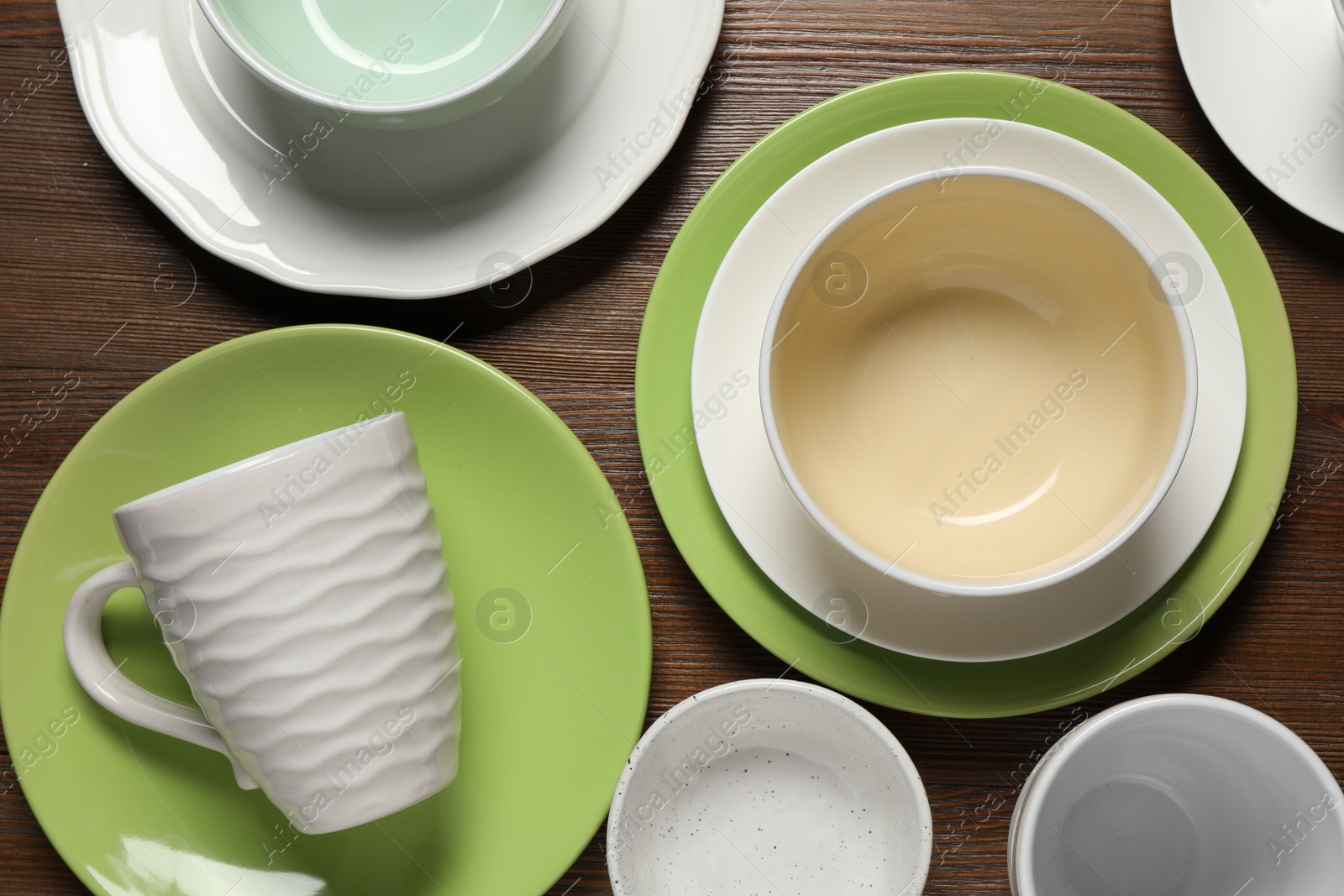 Photo of Beautiful ceramic dishware and cup on wooden table, flat lay