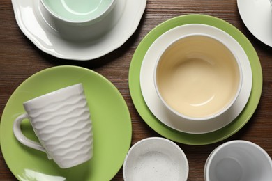 Beautiful ceramic dishware and cup on wooden table, flat lay