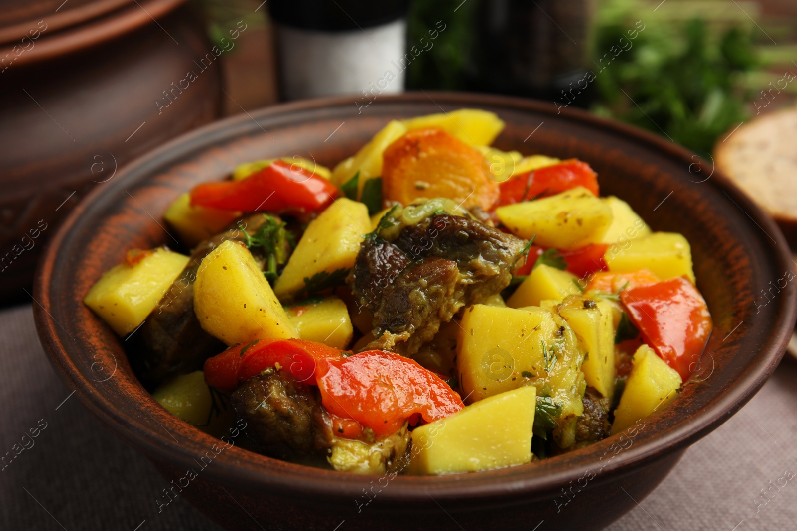 Photo of Tasty cooked dish with potatoes in earthenware on table, closeup