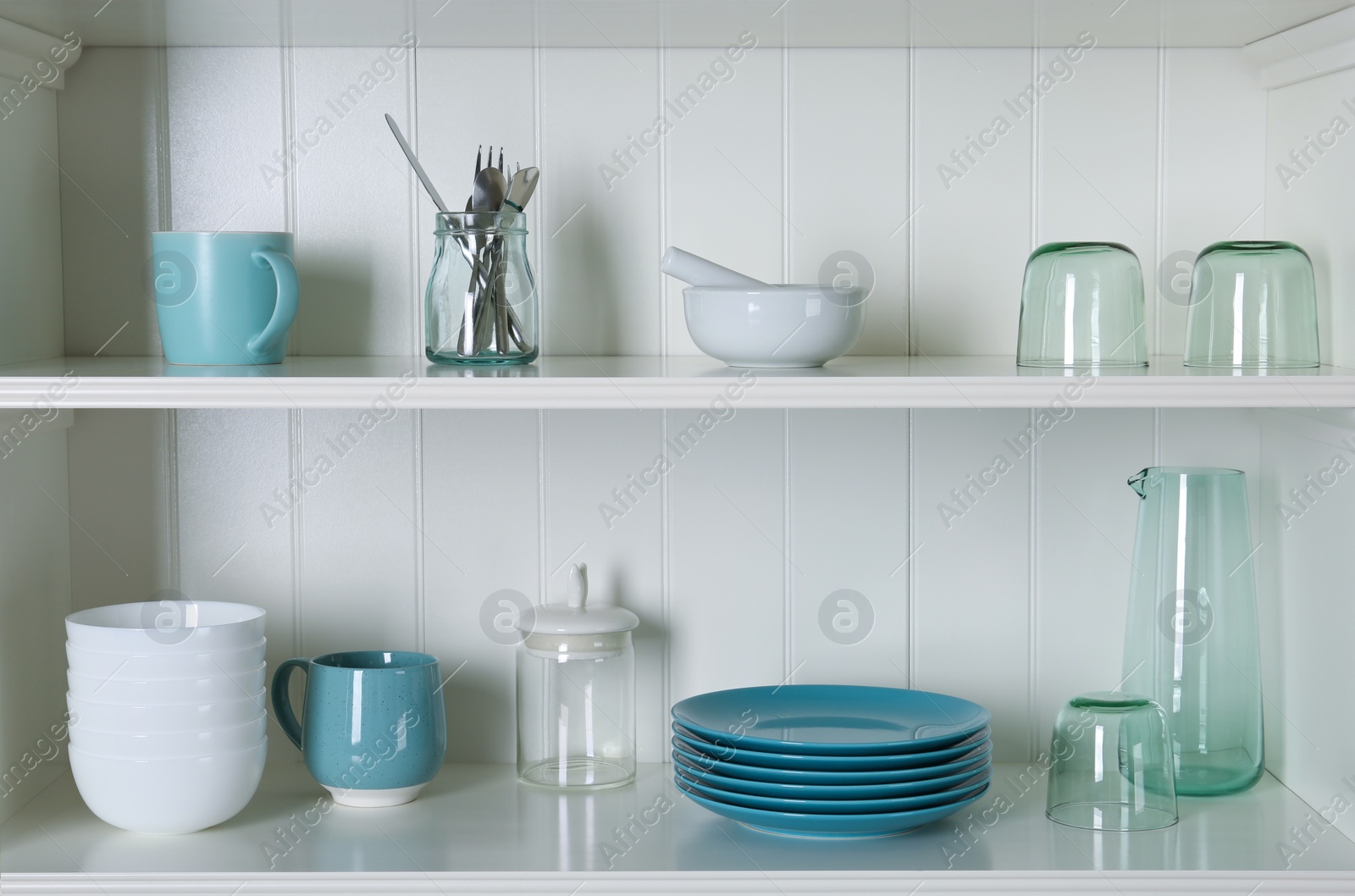 Photo of White shelving unit with set of dishware