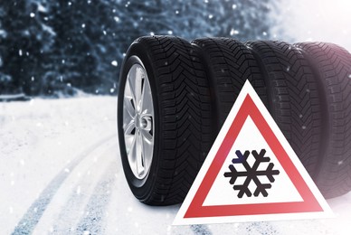 Set of wheels with winter tires and road sign outdoors