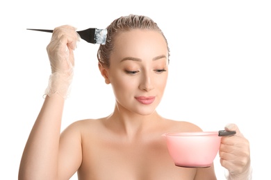 Photo of Young woman dyeing her hair against white background