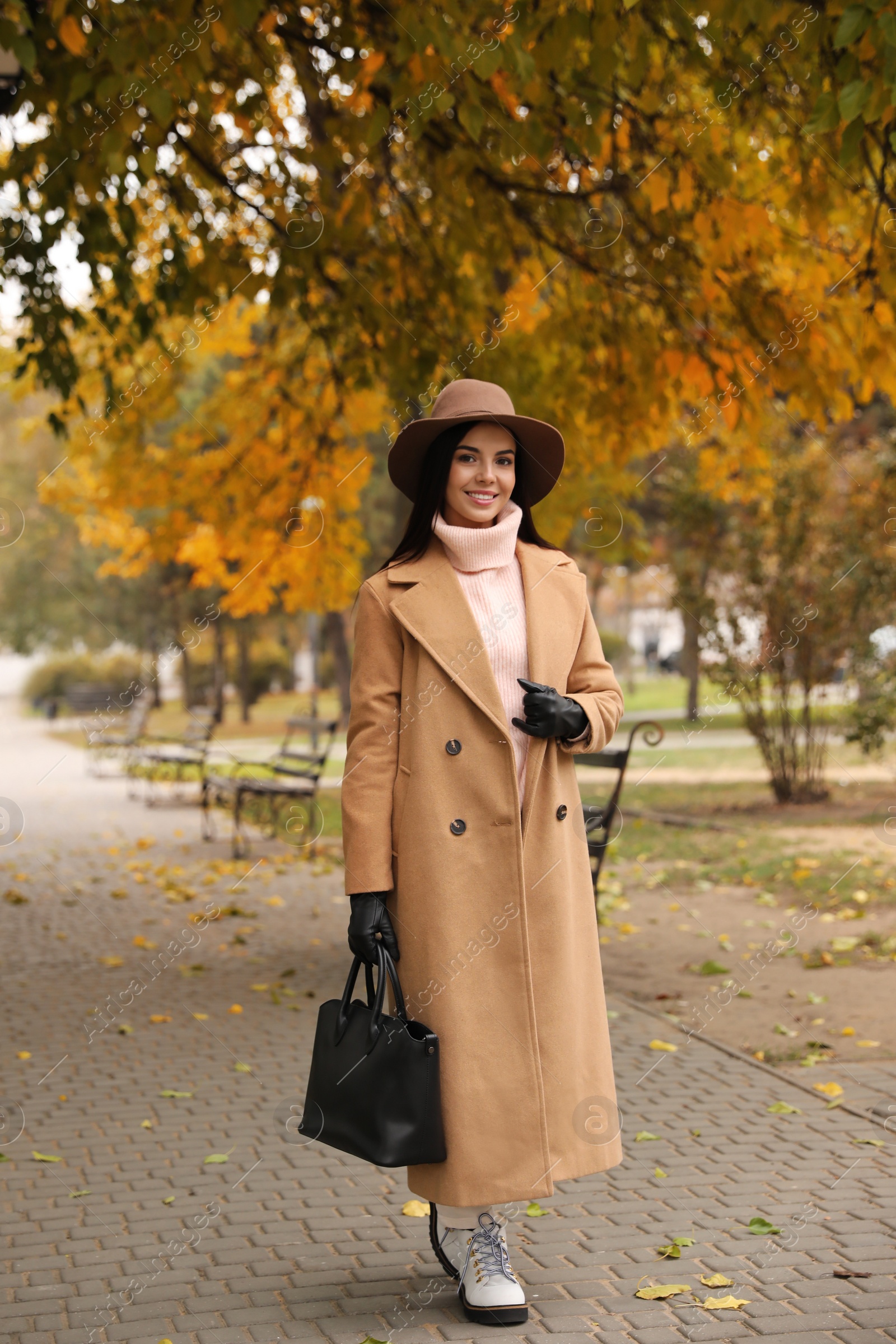 Photo of Young woman wearing stylish clothes in autumn park