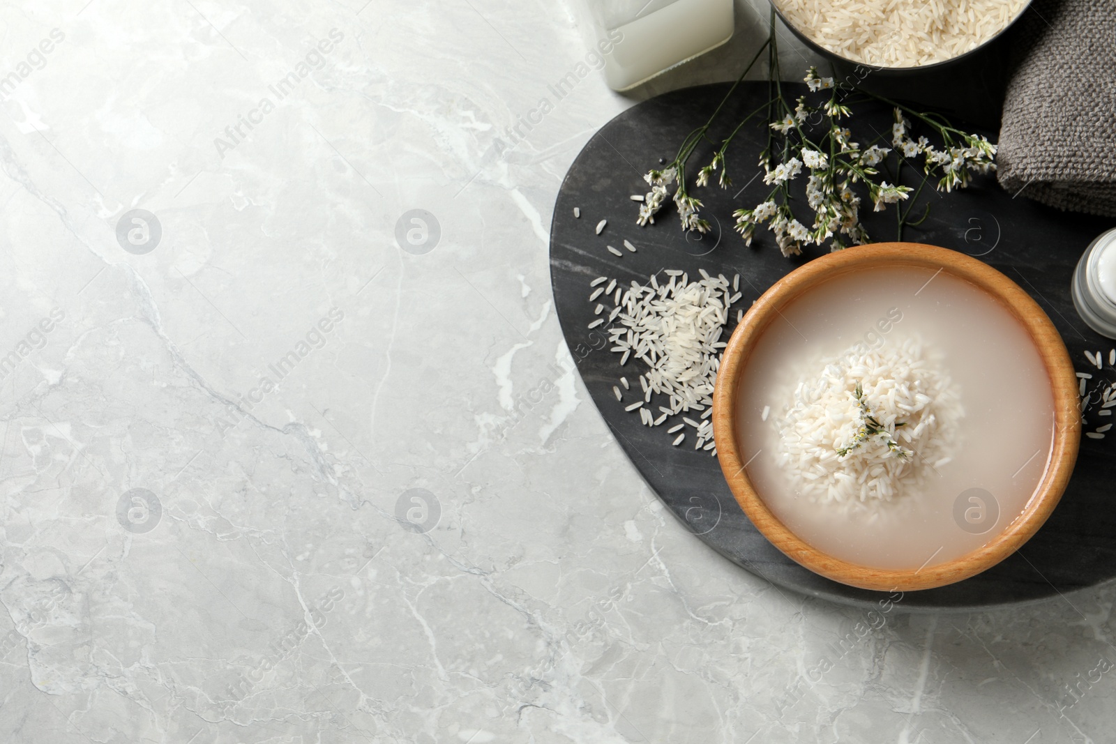 Photo of Flat lay composition with soaked rice and grains on light grey marble table. Space for text