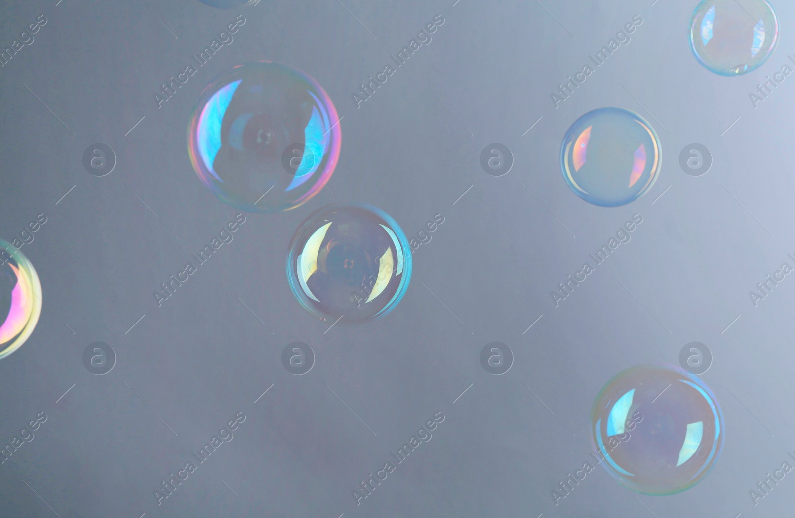 Photo of Beautiful transparent soap bubbles on gray background