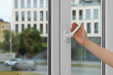 Photo of Woman opening white plastic window at home, closeup