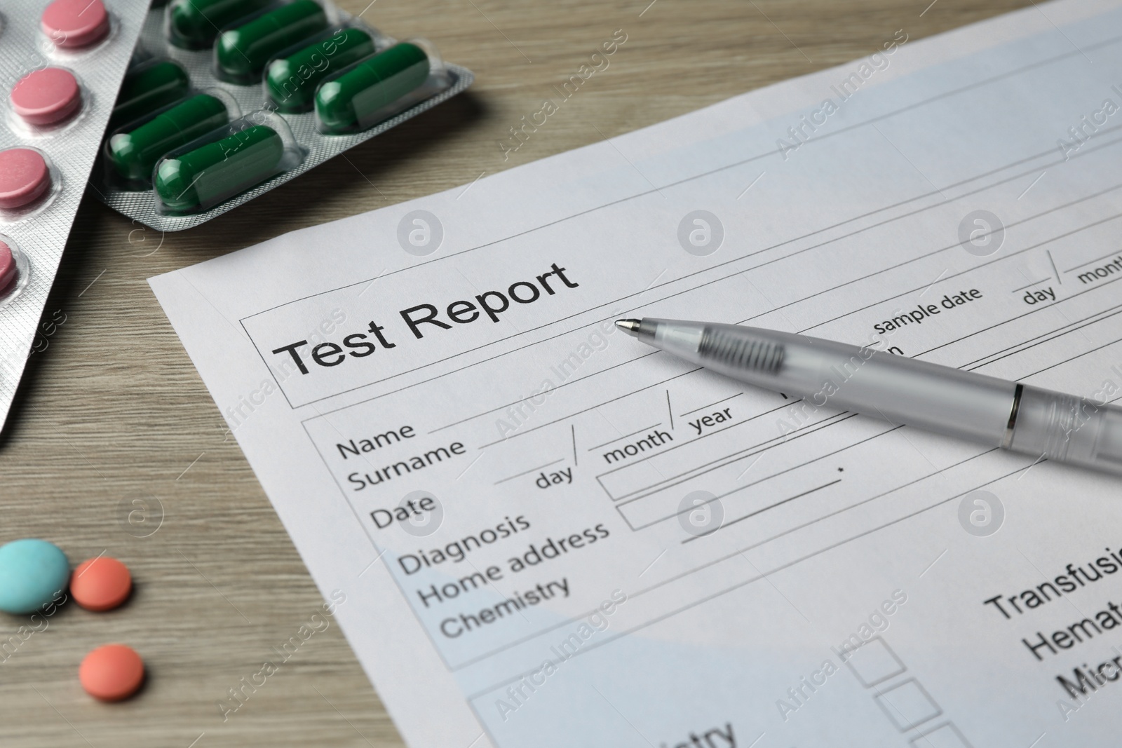 Photo of Drug test result form, pills and pen on wooden table, closeup