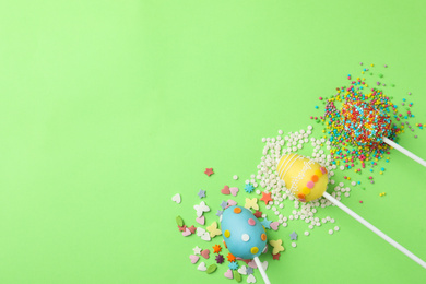 Photo of Egg shaped cake pops and space for text on green background, flat lay. Easter celebration