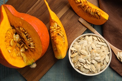 Photo of Flat lay composition with raw pumpkin seeds on blue wooden table