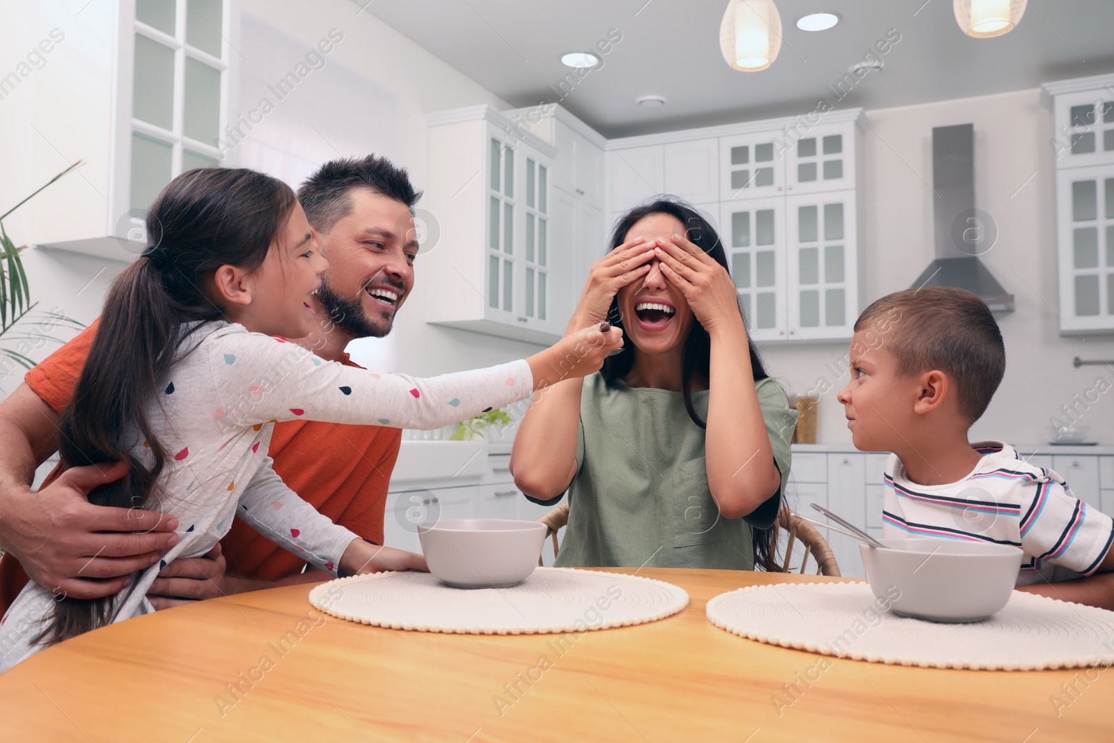 Photo of Happy family with children having fun during breakfast at home