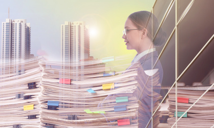 Multiple exposure of businesswoman, documents and cityscape