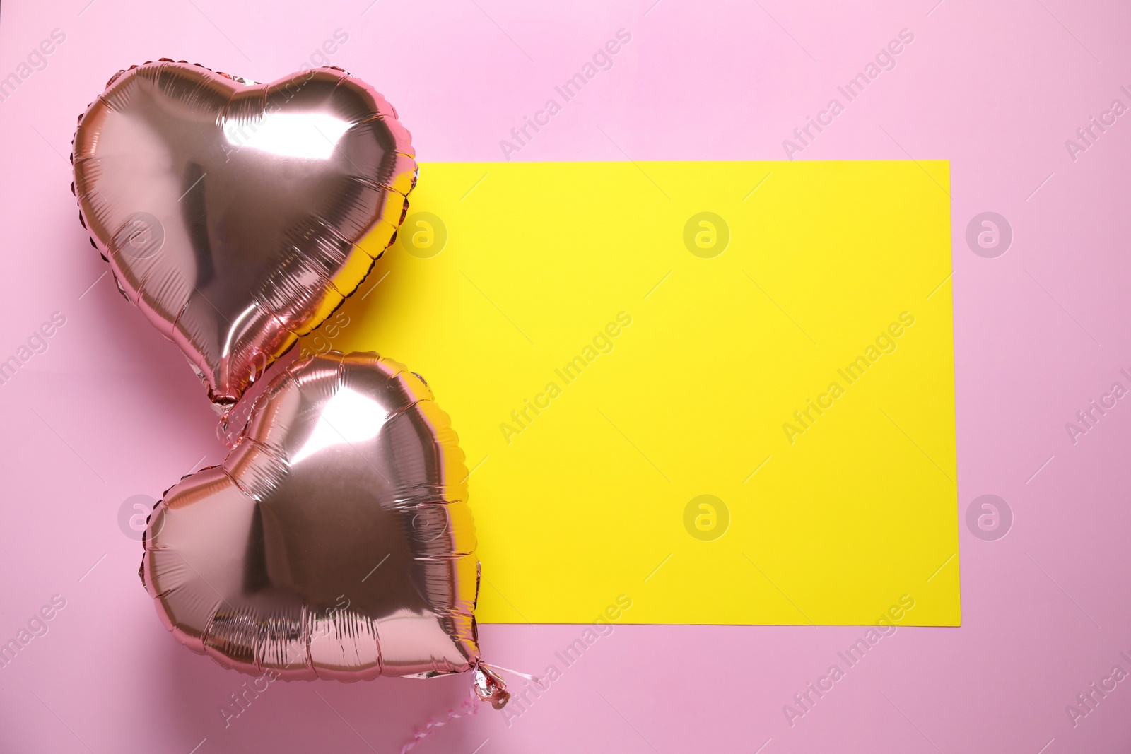 Photo of Heart shaped balloons and yellow card on pink background, flat lay. Space for text