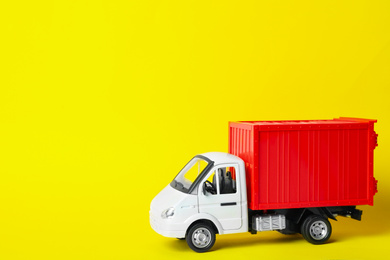 Photo of Toy truck on yellow background, space for text. Logistics and wholesale concept