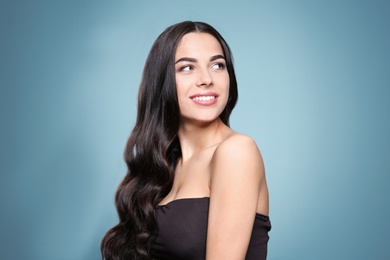 Portrait of beautiful model with gorgeous curly hair on color background