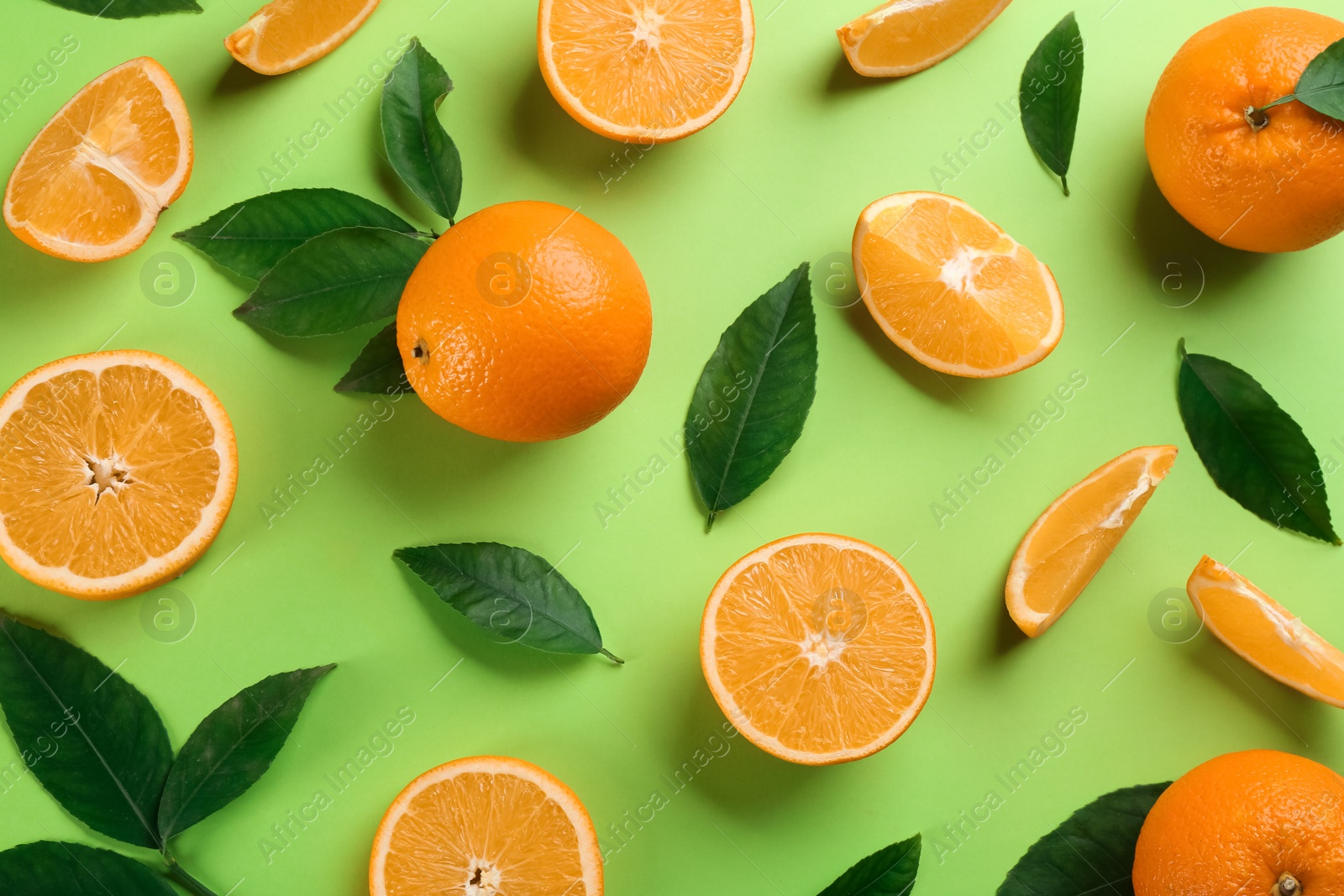 Photo of Delicious oranges on green background, flat lay
