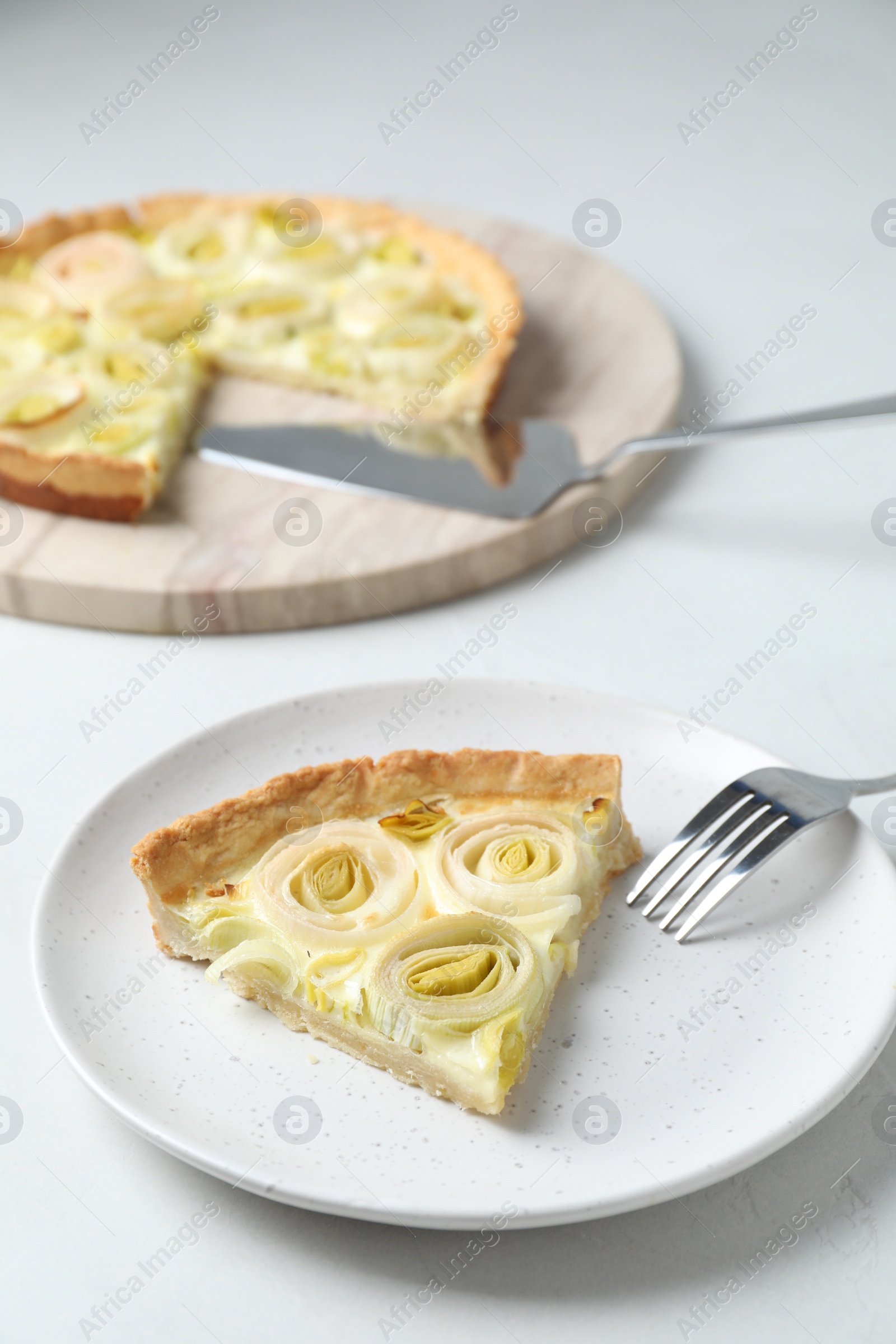 Photo of Piece of tasty leek pie served on white table