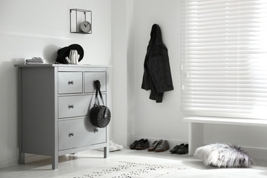 Photo of Grey chest of drawers in stylish room. Interior design