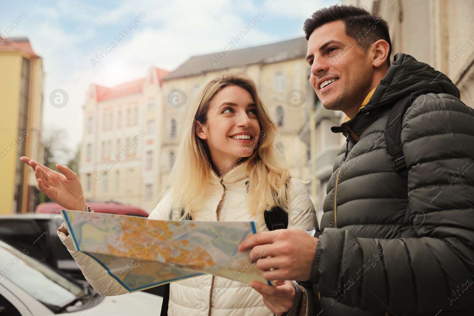 Photo of Couple of tourists with map on city street