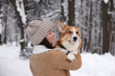 Photo of Woman with adorable Pembroke Welsh Corgi dog in snowy park