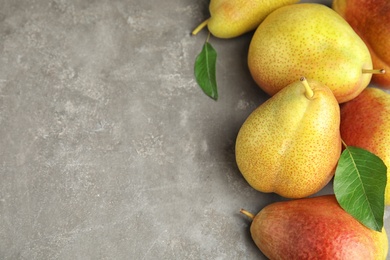 Photo of Ripe juicy pears on grey stone table, flat lay. Space for text