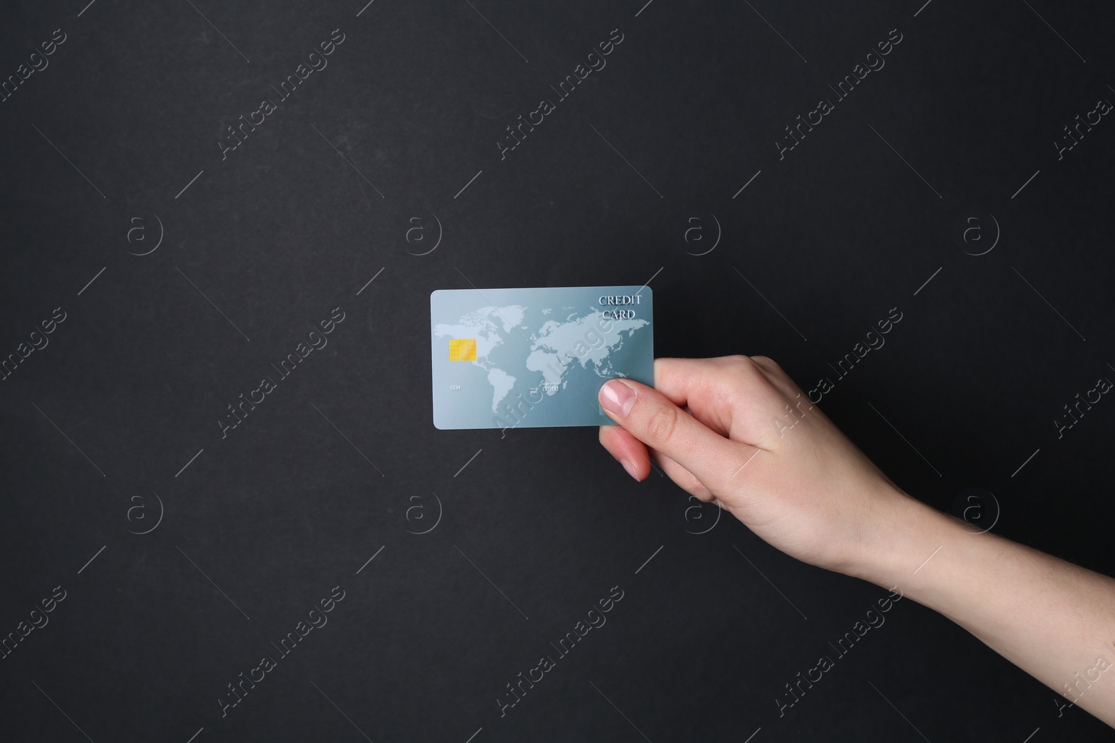 Photo of Woman holding credit card on black background, closeup